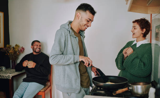 istock Multiracial flatmates talking and laughing while cooking a meal in a kitchen at home 1489419605