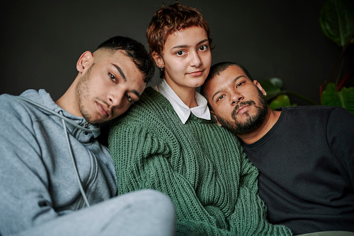 Group portrait of multiracial male gay friends and non-binary person looking at the camera. LGBTQIA Lifestyle and domestic life