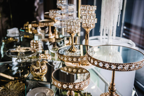 istock Table with plates stands for candy bar, catering. Decorating an event in restaurant. Wedding hall with atmospheric decor. Golden geometric decorative elements decor. Luxury reception. Setting, setup. 1489419944