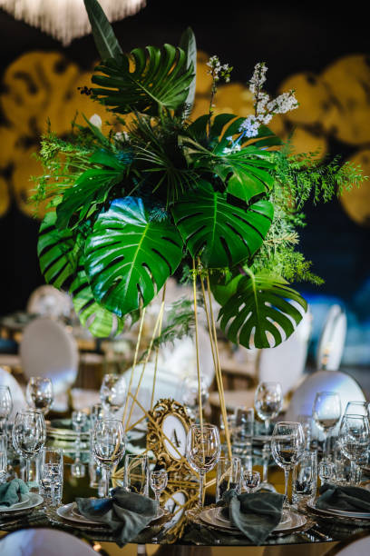 istock Banquet decoration composition flower greenery in hall. Luxury wedding reception. Table setting, setup. Trendy decor for birthday party. Round served tables for guests, plate, glasses, green napkins. 1489420997