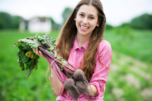 Young woman holding fresh beets