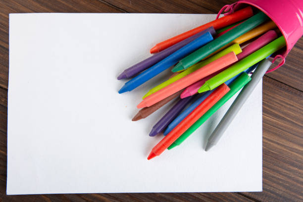 colored crayons and blank page on the wooden table stock photo