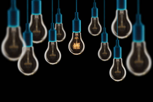 Idea and teamwork concept - Vintage incandescent bulbs on black background stock photo