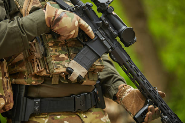 istock Sniper equipped with modern assault rifle with optical scope training outdoor. Ukrainian soldier practicing at the shooting range 1489424892