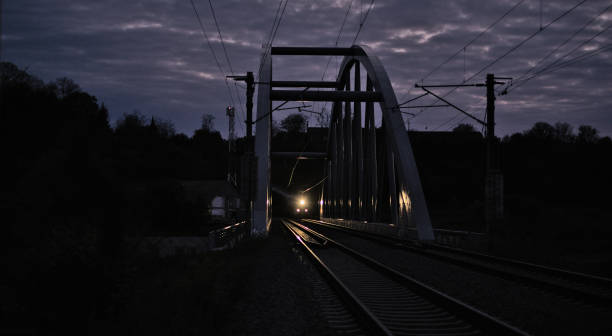 treno merci che attraversa un ponte d'acciaio di notte - segesvar foto e immagini stock