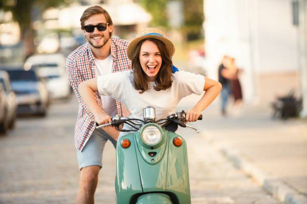 istock Laughing couple riding on a scooter in town 1489429595