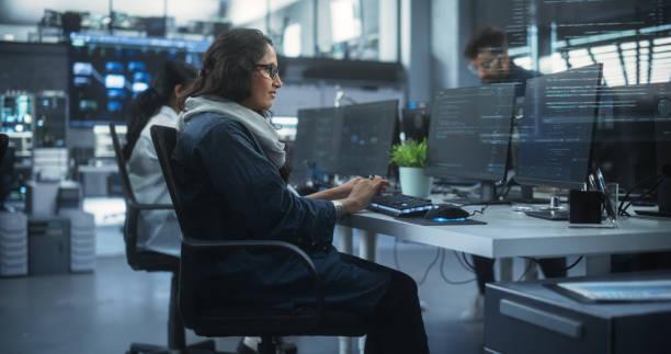 istock Diverse Young Indian Colleagues Working on Computers in a Research Laboratory. Focus on Female Software Developer Colleague Working on a Solution for Their Collaborative Industrial Tech Project 1489430975