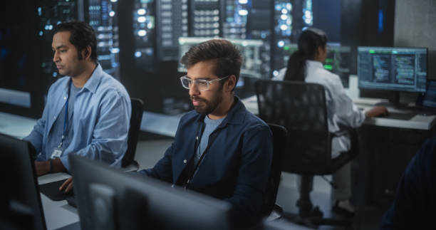 istock Portrait of a Handsome Indian Engineer Working on Desktop Computer in a Technological Office Environment. Research and Development Department Writing Software Code for an Innovative Internet Project 1489431568