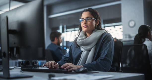 istock Portrait of a Thoughtful South Asian Engineer Working on Computer in a Technological Corporate Office. Young Woman Writing Software Code for an Innovative Internet and Software as a Service Project 1489431877