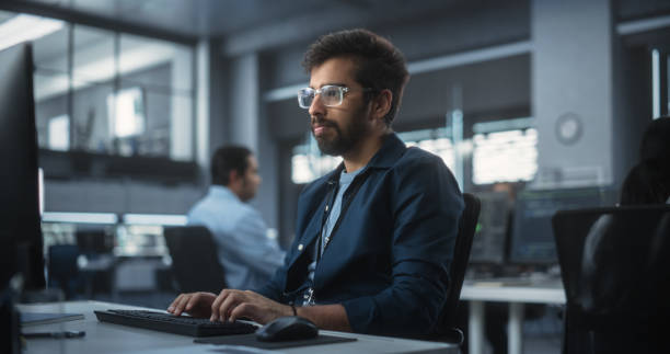 istock Portrait of an Indian Engineer Working on Desktop Computer in a Technological Office Environment. South Asian Software Developer Researching New Ideas to Problem Solve a Technical Assignment 1489431929