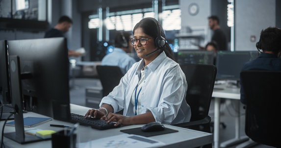 Positive Technical Support Manager Talking on a Call, Providing Help Desk Solutions to a Customer Experiencing Troubleshooting Issues with a Product. Indian Female Successfully Solving the Problem