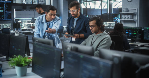 istock Team of Three Multiethnic Diverse Software Developers Talk, Discuss and Collaborate on an AI Project. Empowered Young Indian Specialists Work on Digital E-Commerce Startup Business 1489433358