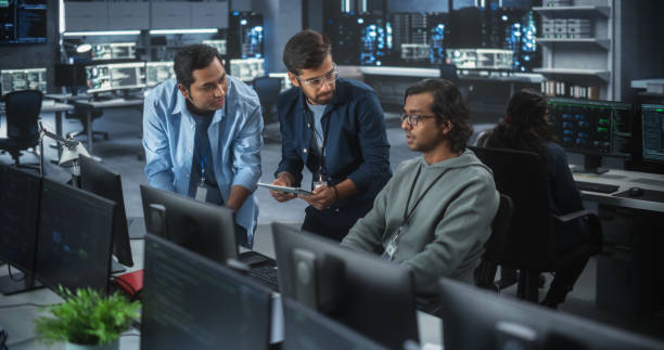 istock Team of Three Multiethnic Diverse Software Developers Talk, Discuss and Collaborate on an AI Project. Empowered Young Indian Specialists Work on Digital E-Commerce Startup Business 1489433381