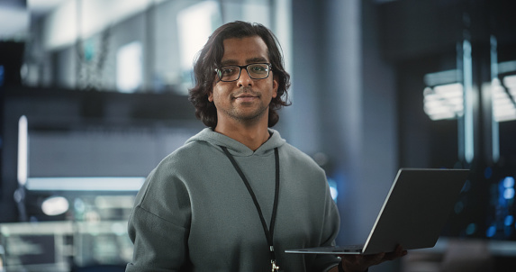 Young Indian Software Engineer Using Laptop Computer In Data Center ...