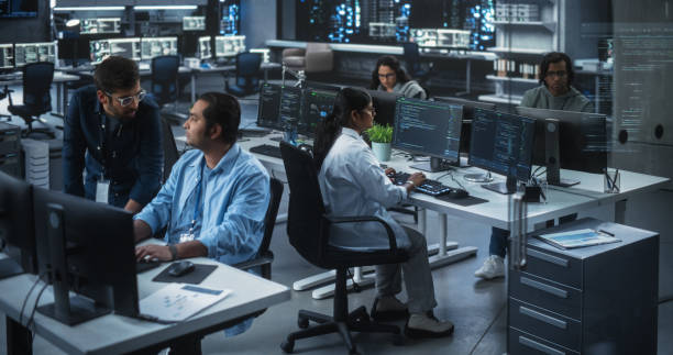 istock Young Team of South Asian Specialists Working on Computers and Having a Conversation at a Workplace. Two Male Software Developers Discussing a Solution for Their Artificial Intelligence Project 1489433871