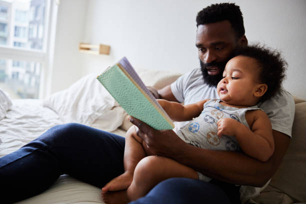 istock Loving dad reading his baby boy a book in bed 1489434445