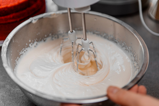Close up of female hands working on domestic cake baking in a home kitchen