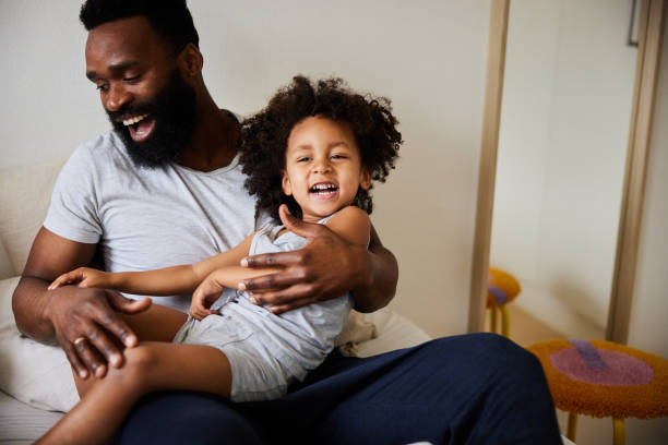 istock Laughing little boy sitting on her father's lap 1489438372