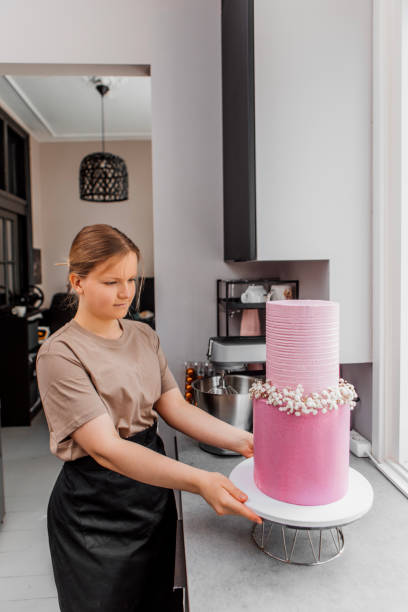 istock Beautiful female home baker preparing a wedding cake for delivery 1489438387