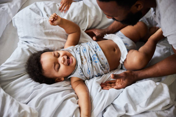 istock Loving dad looking down at his baby boy lying on a bed 1489438523