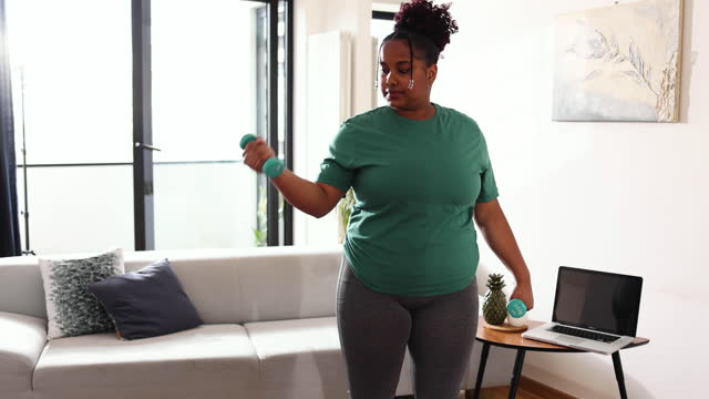 Young African woman exercising at home