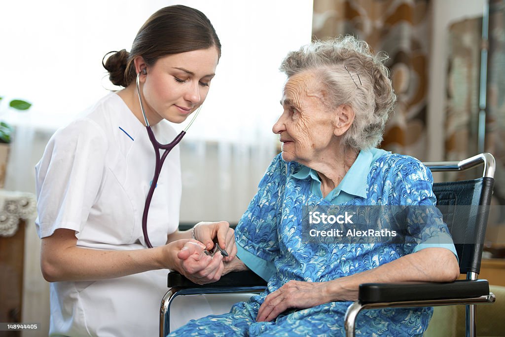 In-home nurse helping an elderly woman Senior woman with her caregiver at home Community Outreach Stock Photo