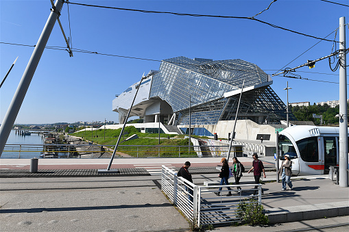 Lyon, France-05 03 2023: People getting off a tram in front of the Musée des Confluences building in Lyon, France.
