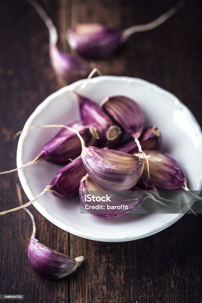 Garlic Cloves close up of purple garlic cloves in a small bowl Alternative Medicine Stock Photo