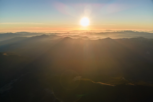Beautiful mountain panoramic landscape with hazy peaks and foggy valley at sunset.
