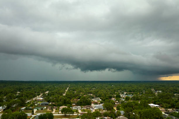 Dark stormy clouds forming on gloomy sky before heavy rainfall over suburban town area.