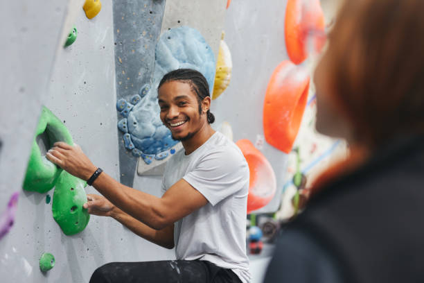 istock Man On Climbing Wall At Indoor Activity Centre Receiving Personal Lesson From Coach 1489454223