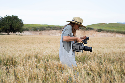 woman using video camera at farm field