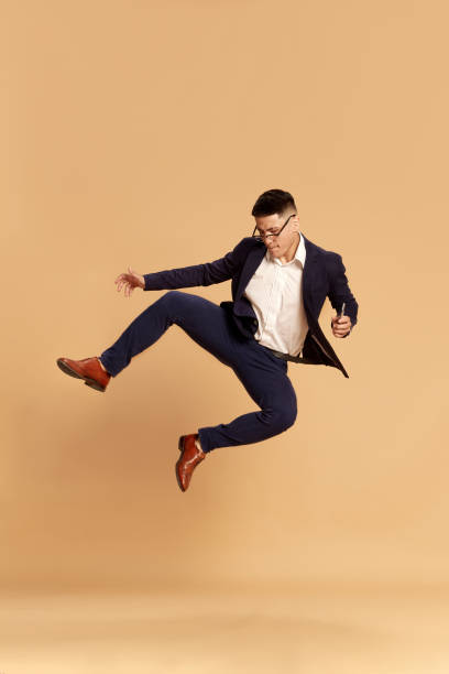 istock Portrait with happy man, guy wearing classical suit dancing after good job interview over beige color studio background. Hired 1489459321