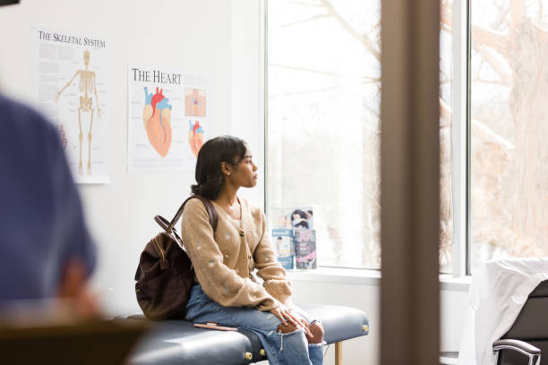 istock Female college student looks out window while waiting for doctor 1489462400