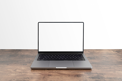 modern laptop computer with blank screen on wooden table against white background