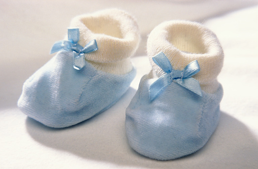Pair of traditional soft blue small baby shoes close up