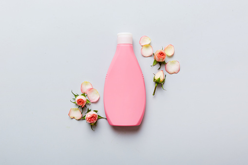 Fancy healthcare bottles for cream with rose flower. Natural oranic spa cosmetics concept. Mockup, template, Top view.