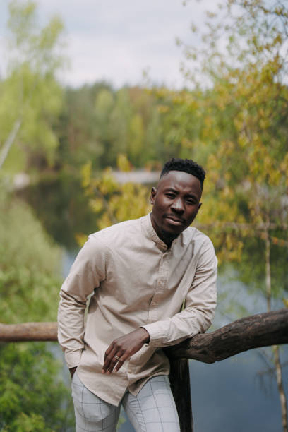 istock Young african man stands on wooden bridge during outing. 1489465700