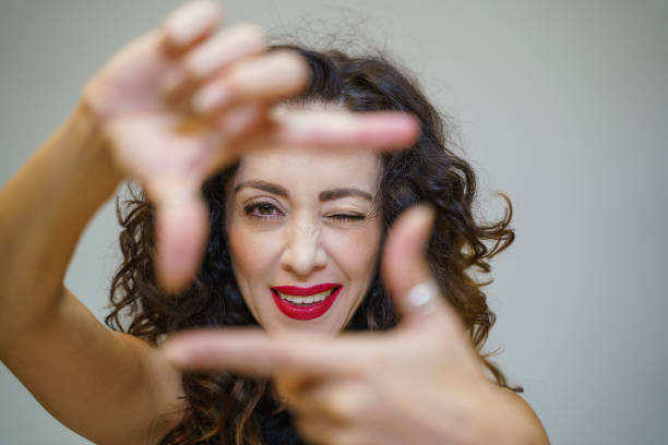 istock Young woman smiling creating square frame with her fingers around her face 1489466498