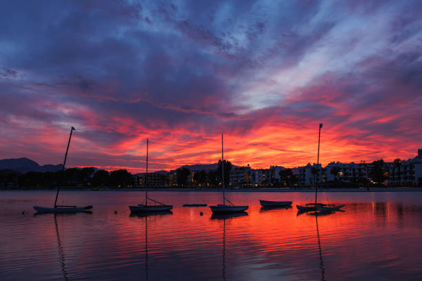 Sunset over Port de Alcudia, Majorca, Balearic islands, Spain Sunset over Port de Alcudia. Silhouette of ships in Bay of Alcudia in Mallorca bay of alcudia stock pictures, royalty-free photos & images