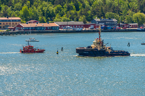 Gothenburg, Sweden - May 29 2022: Tow boat Switzer Tyr passing local Pilot vessel.