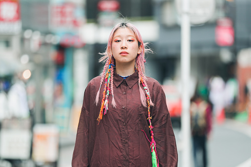 Asian teenage girl looking at camera at the street in Japan