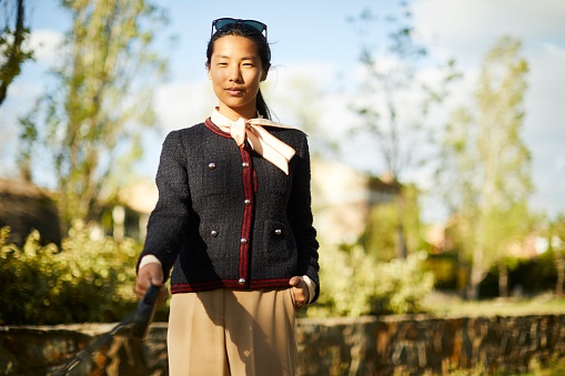 A businesswoman gripping a leash as her dog pulls, just out of the frame.