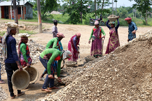 Male and female workers are working in the stone crusher factory ignoring the intense heat. Sylhet, Bangladesh, 8 May 2023.