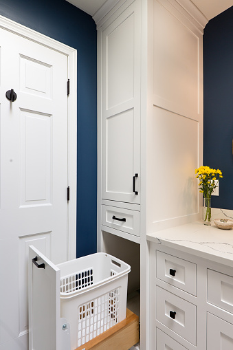 A contemporary modern bathroom design. featuring a laundry basket with laundry