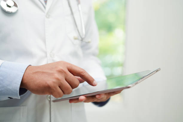 istock Asian man doctor using tablet computer to reading patient report, check up and search for solve treatment health medical online in hospital. 1489473652