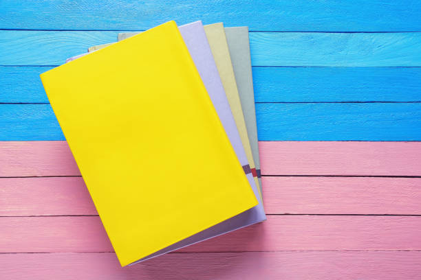 istock Stack of colorful books on blue and pink rustic table. Flat lay. Copy space 1489473929