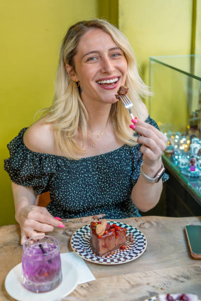 istock Woman eats chocolate and strawberry cake in cafe 1489474214
