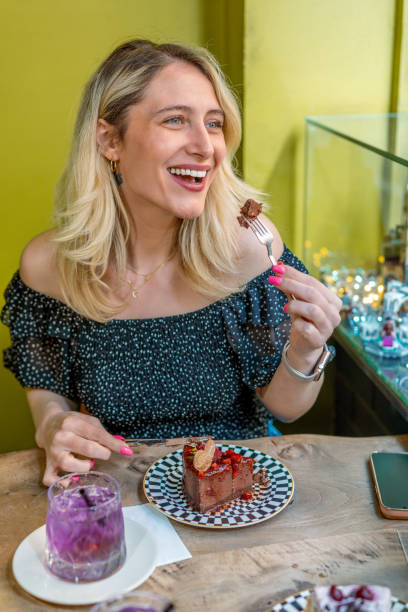 istock Woman eats chocolate and strawberry cake in cafe 1489474771
