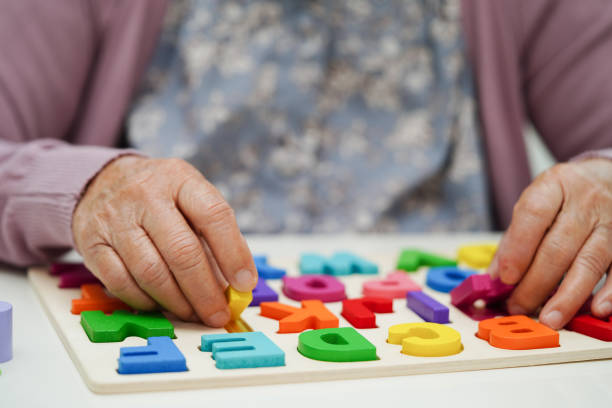 istock Asian elderly woman playing puzzles game to practice brain training for dementia prevention, Alzheimer disease. 1489475232